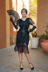 A black 1920s flapper dress with sleeves, black sequins, beads and fringes