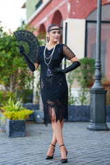 A black 1920s flapper dress with sleeves, black sequins, beads and fringes