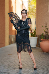 A black 1920s flapper dress with sleeves, black sequins, beads and fringes