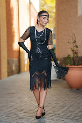 A black 1920s flapper dress with sleeves, black sequins, beads and fringes