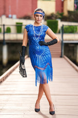 A 1920s Flapper Dress in Electric Blue. It has beads, sequins and finished with a layer of fringes around the hem.