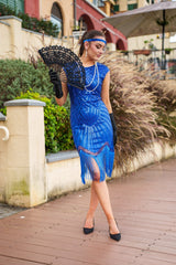 A 1920s Flapper Dress in Electric Blue. It has beads, sequins and finished with a layer of fringes around the hem.