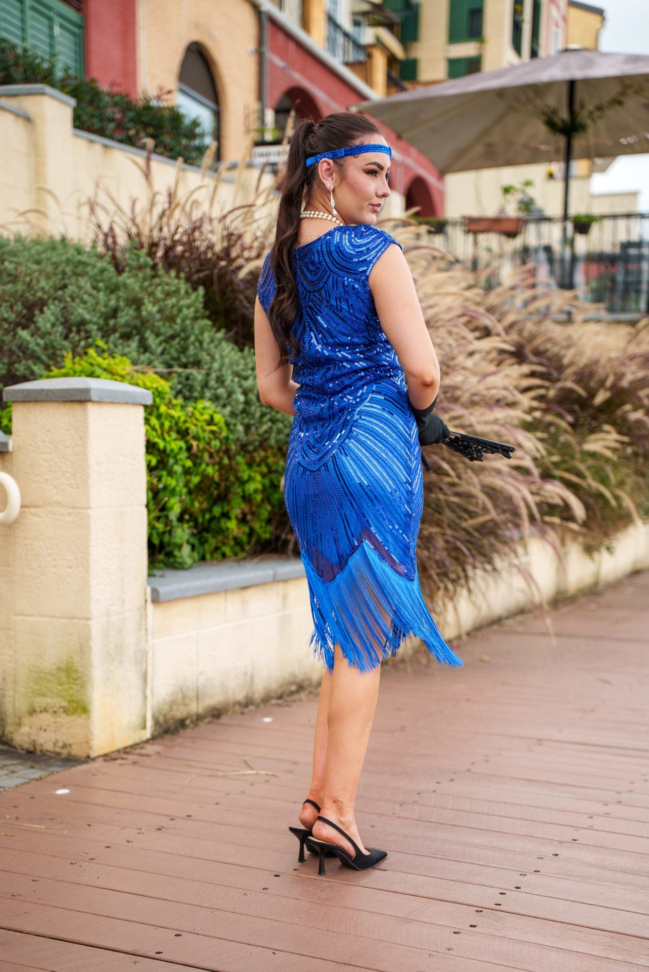 A 1920s Flapper Dress in Electric Blue. It has beads, sequins and finished with a layer of fringes around the hem.