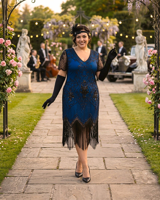 A woman walks down a stone path in a garden wearing a blue 1920s-style flapper dress with black fringe, black lace sleeves, black gloves, a black headband, and black heels. Statues, flowers, and string lights are visible in the background.