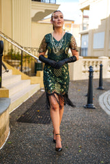 A Green 1920s Gatsby Dress with Sleeves, Green and Gold Sequins, Beads and Fringes around the Hem.