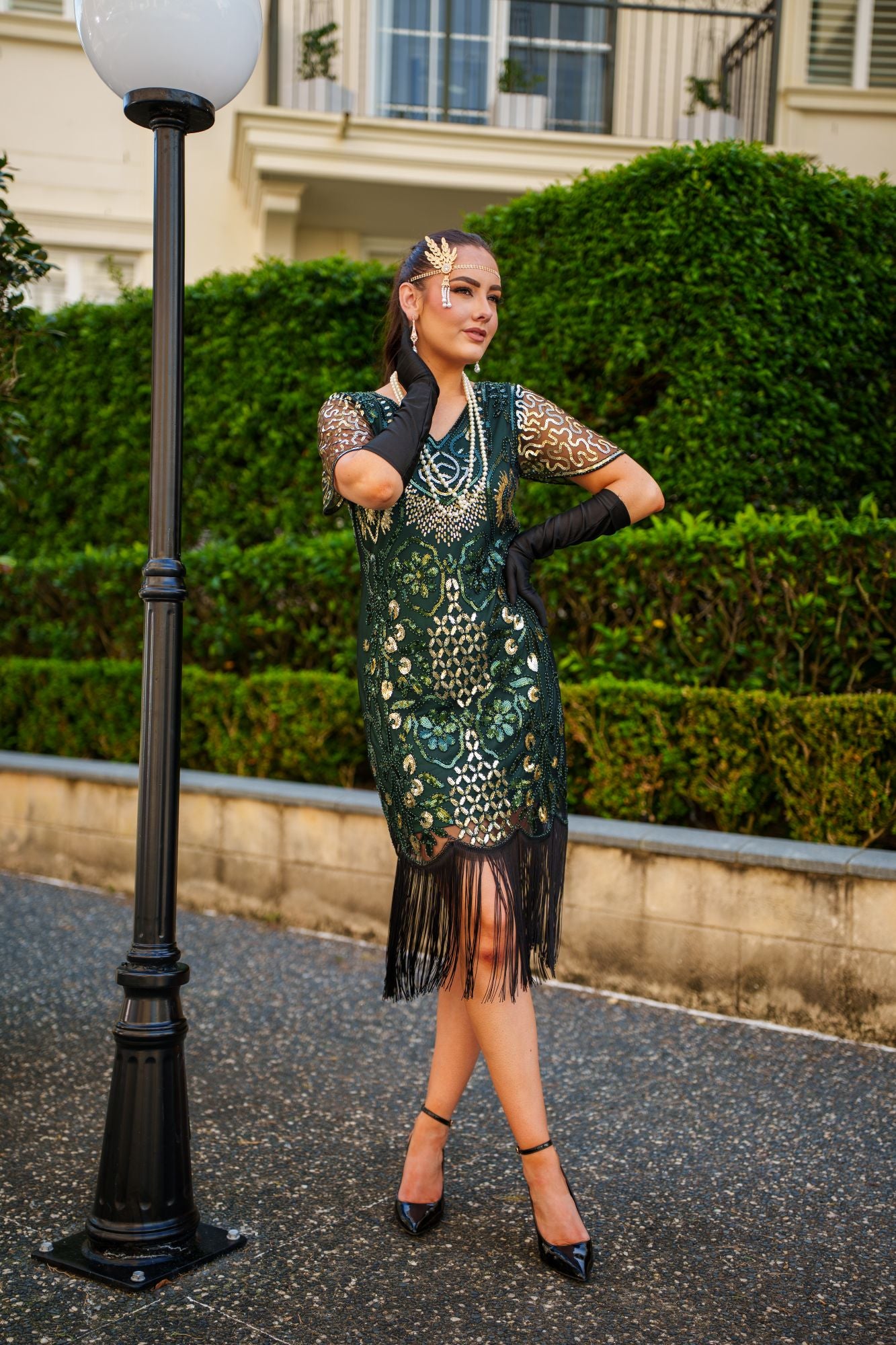 A Green 1920s Gatsby Dress with Sleeves, Green and Gold Sequins, Beads and Fringes around the Hem.
