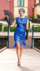 A 1920s Flapper Dress in Electric Blue. It has beads, sequins and finished with a layer of fringes around the hem.