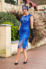 A 1920s Flapper Dress in Electric Blue. It has beads, sequins and finished with a layer of fringes around the hem.