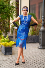 A 1920s Flapper Dress in Electric Blue. It has beads, sequins and finished with a layer of fringes around the hem.