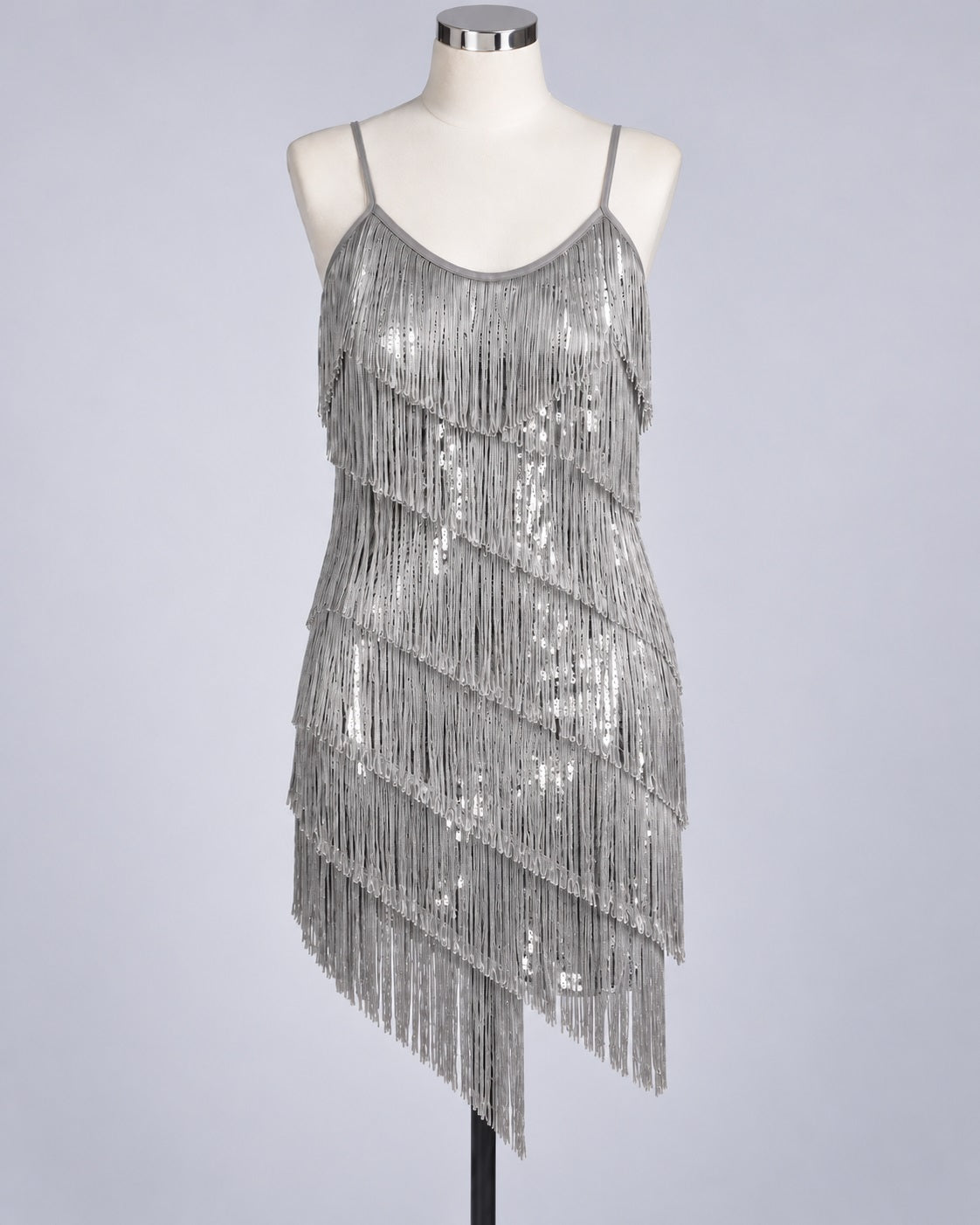 A silver sequined 1920z fringe flapper dress displayed on a white mannequin against a light gray studio background.