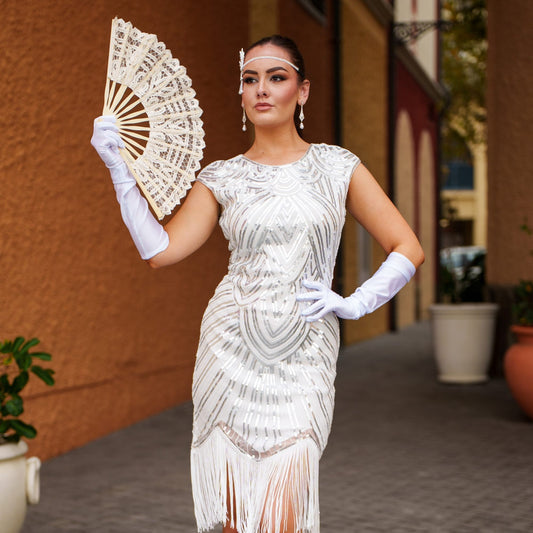A stunning white 1920s flapper dress with sequins, beads and fringes around the hem. 