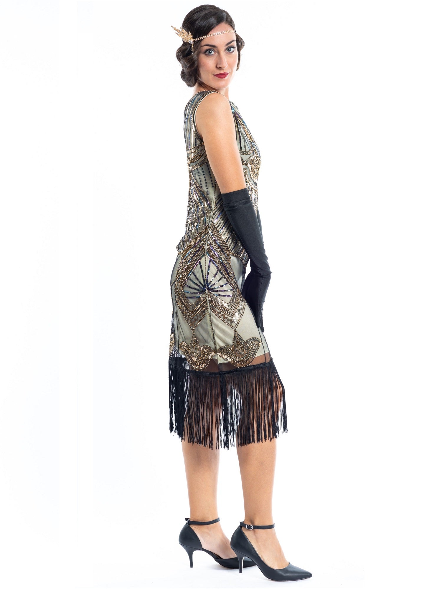 A gold flapper dress with a 1920s deco pattern of sequins, beads and fringes around the hem - side view