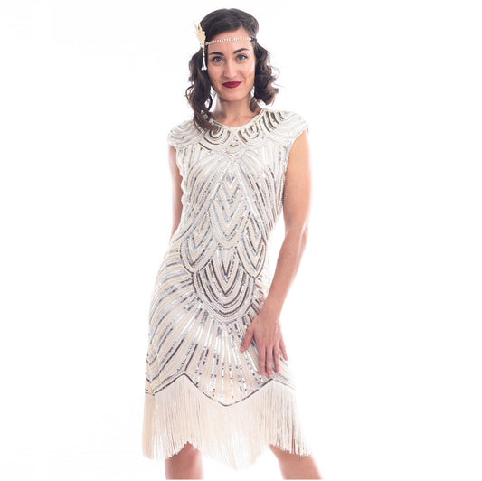 A close view of a vintage 1920s flapper dress in ivory white with beads, sequins and fringes around hem.